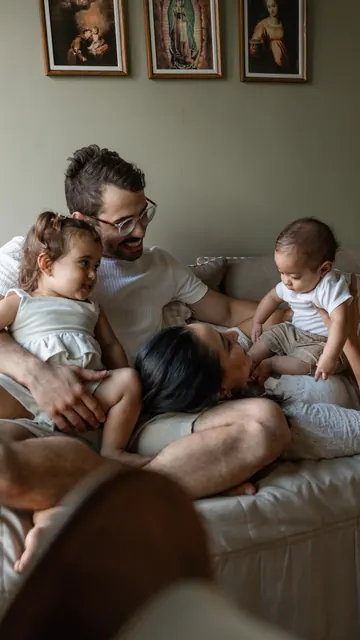 Família reunida no sofá com as duas crianças pequenas
