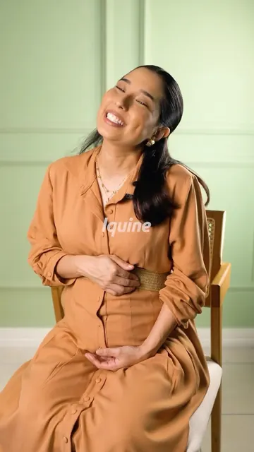 Helô sorrindo, de camisa caramelo, em vídeo para a Iquine